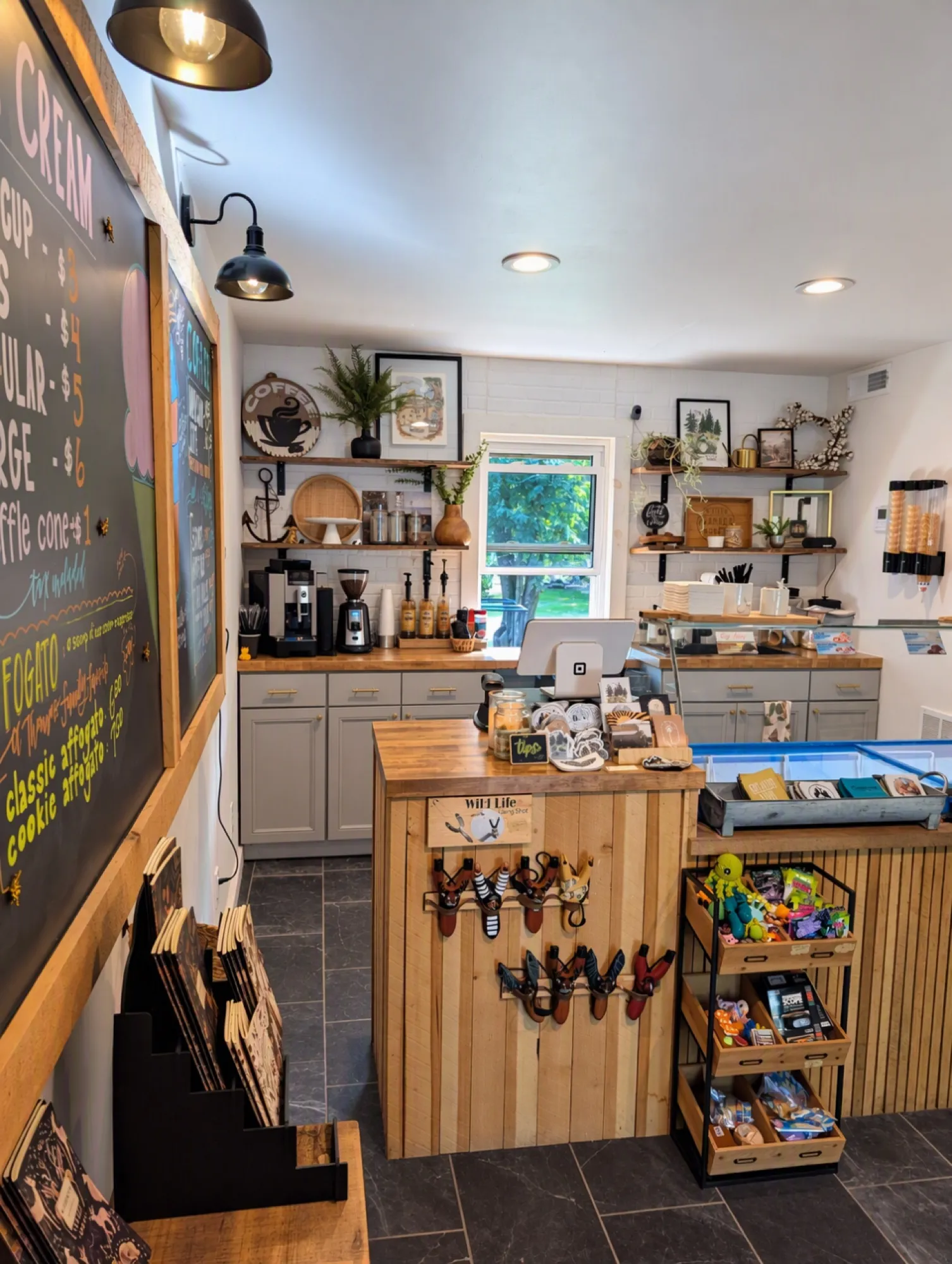 Inside the camp store: chalkboard ice cream menu, espresso machine, wood counter and shelves of local goods