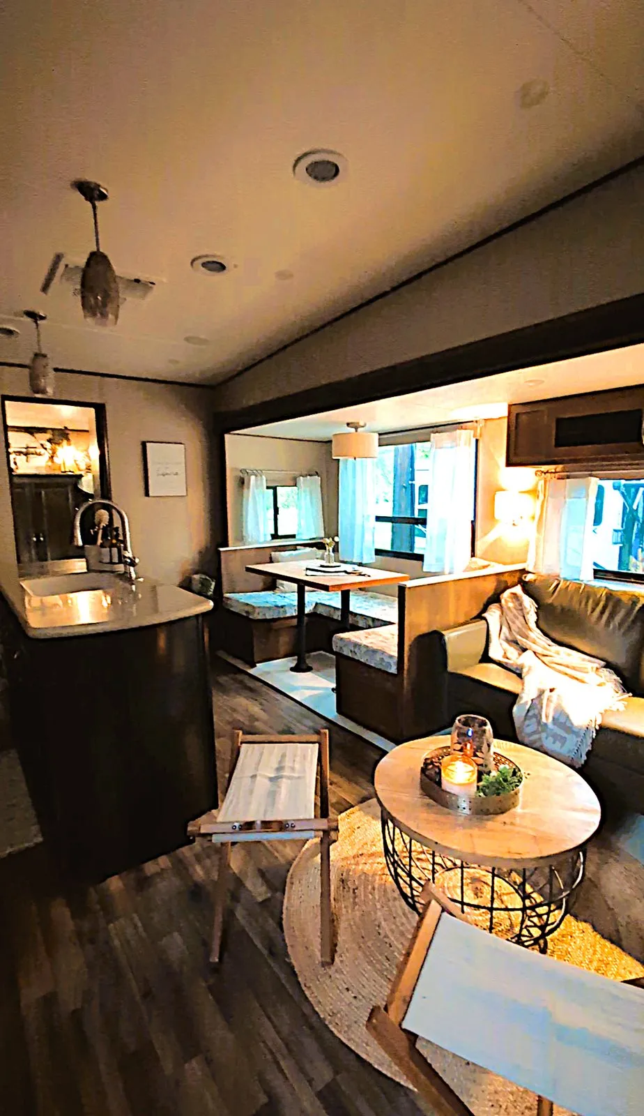 Inside the rental camper: the living area with a sofa, a round coffee table and the kitchen island