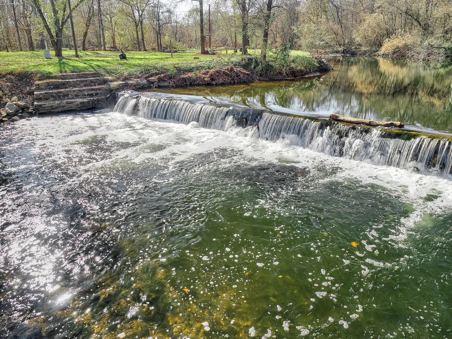 Water spilling over the low stone dam on Conewago Creek