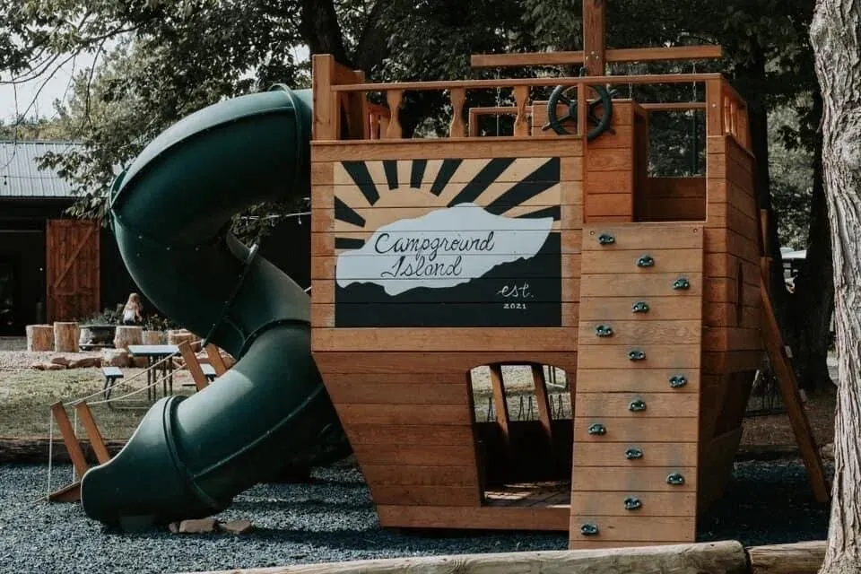The wooden ship playground with a slide and climbing wall