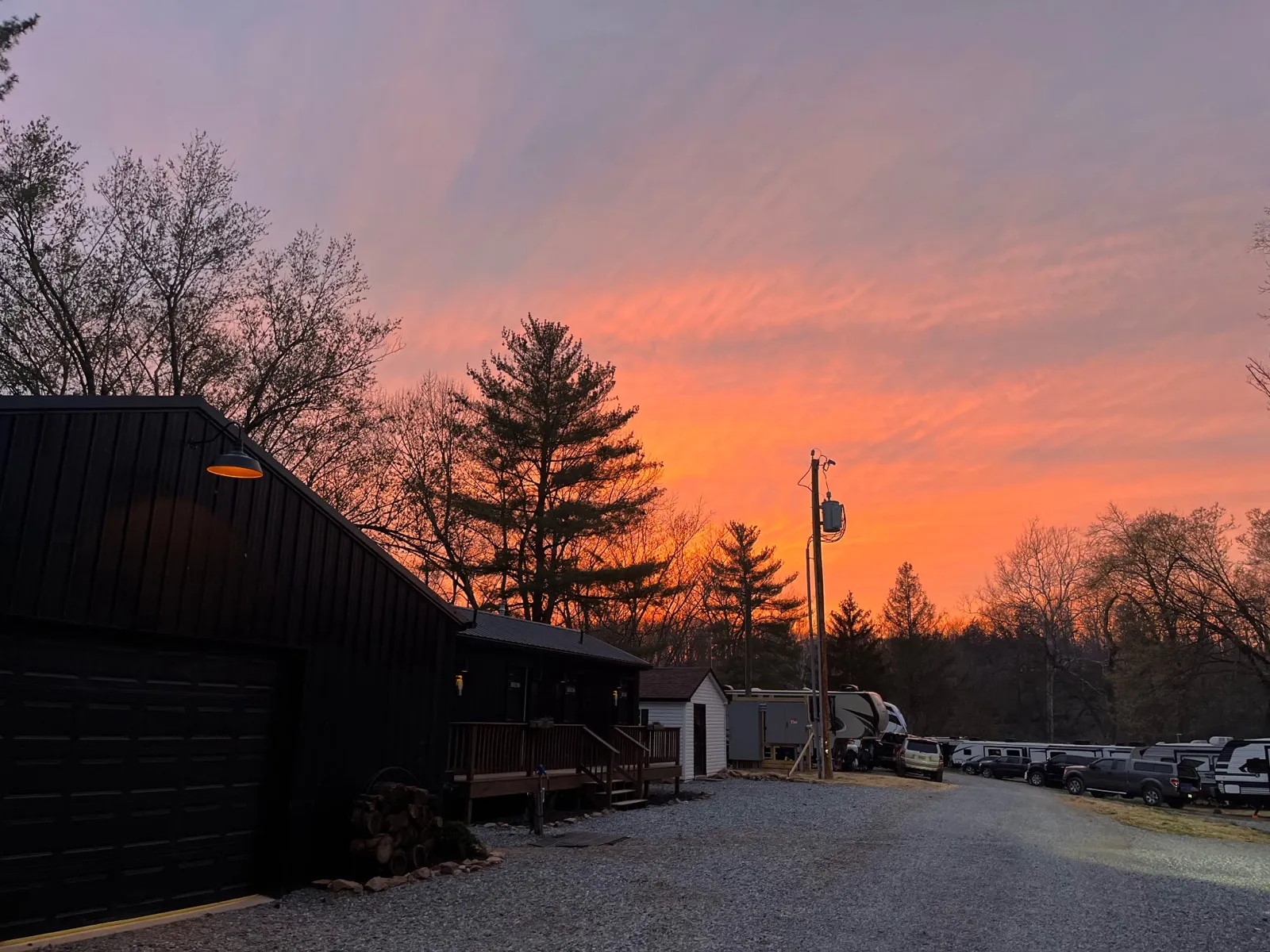 A pink and orange sunset over the rec room and the campground road